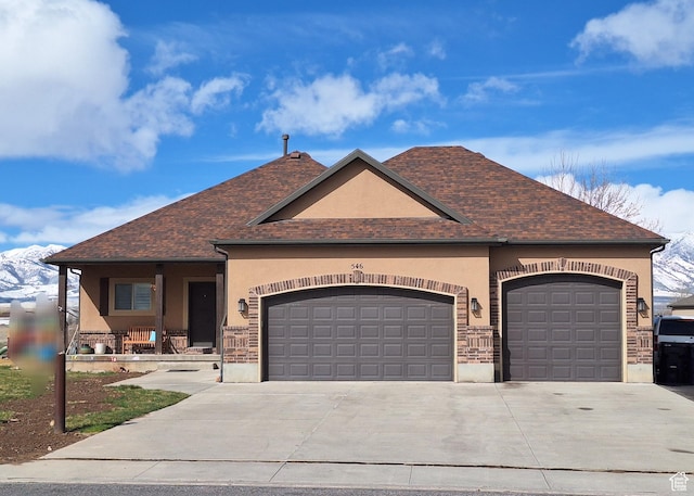 546 S Quirk St, Grantsville, UT 84029 - view of front of home with stucco siding, an attached garage, driveway, covered porch, and a shingled roof