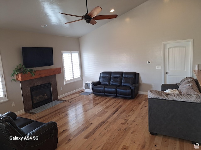 546 S Quirk St, Grantsville, UT 84029 - living room with baseboards, light wood-style flooring, ceiling fan, and a tile fireplace