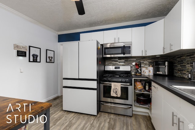 2209 Van Buren Ave, Ogden, UT 84401 - kitchen with decorative backsplash, stainless steel appliances, light wood-style floors, and dark countertops
