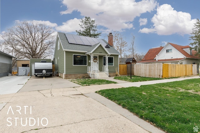 2209 Van Buren Ave, Ogden, UT 84401 - bungalow-style home with fence, a front yard, solar panels, roof with shingles, and driveway