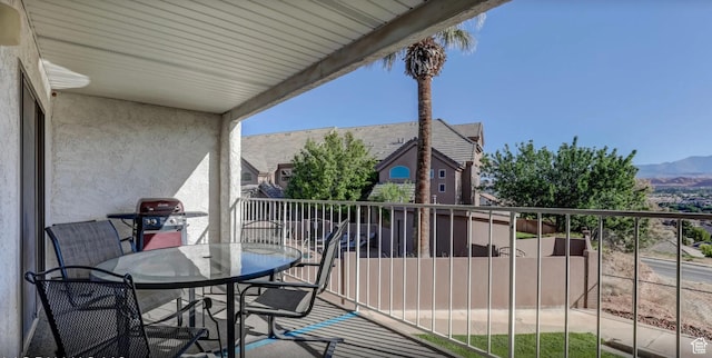 balcony with a grill, outdoor dining space, and a mountain view