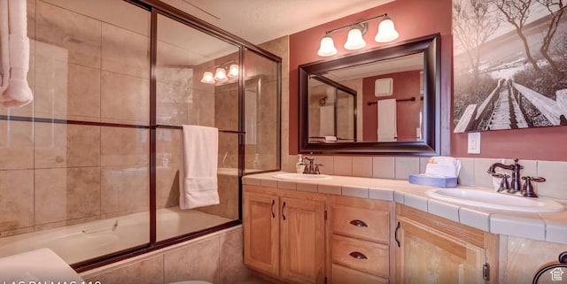 full bath featuring double vanity, a sink, and tiled shower / bath