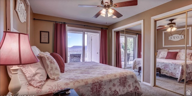 carpeted bedroom featuring a ceiling fan and two closets