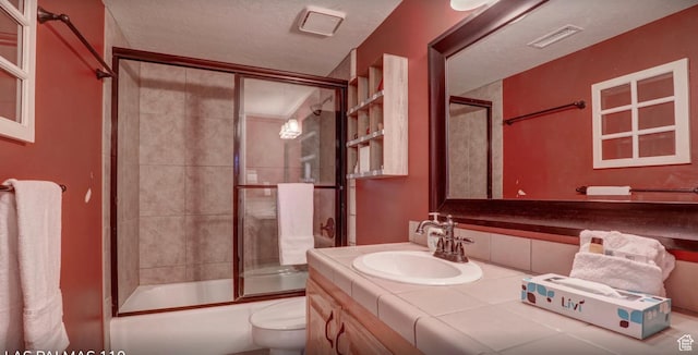 full bath featuring toilet, vanity, enclosed tub / shower combo, and visible vents