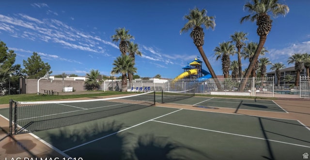 view of sport court with playground community and fence