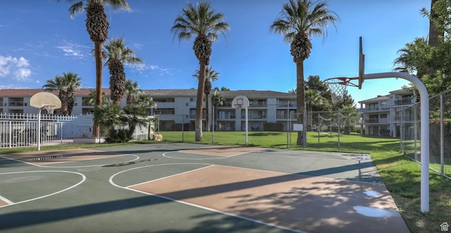 view of sport court featuring community basketball court, fence, a yard, and a residential view