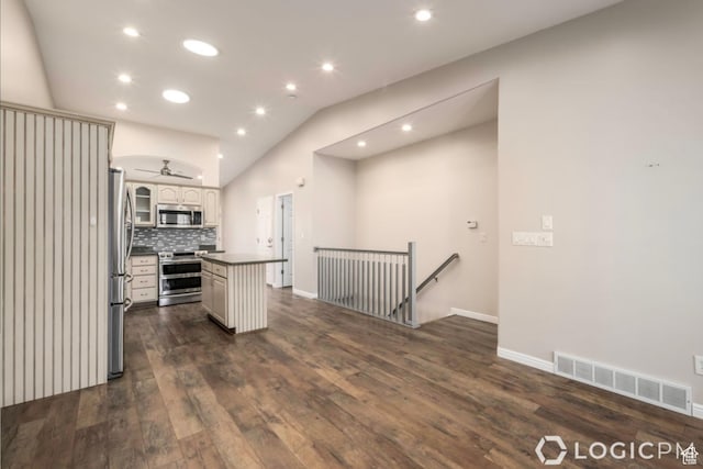 kitchen with dark countertops, visible vents, dark wood-type flooring, appliances with stainless steel finishes, and vaulted ceiling