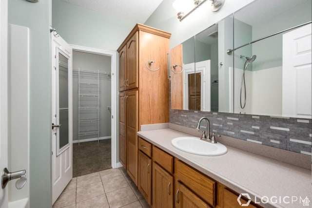 bathroom featuring vanity, backsplash, and tile patterned flooring