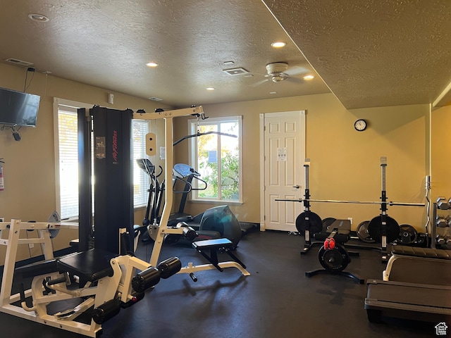 workout room with a textured ceiling and a healthy amount of sunlight