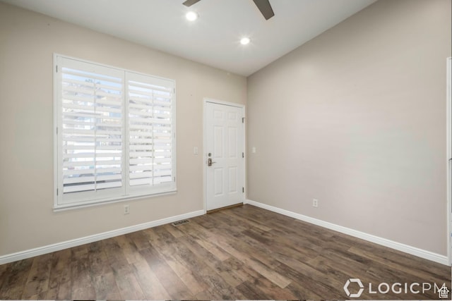 unfurnished room featuring a wealth of natural light, baseboards, dark wood-style flooring, and a ceiling fan