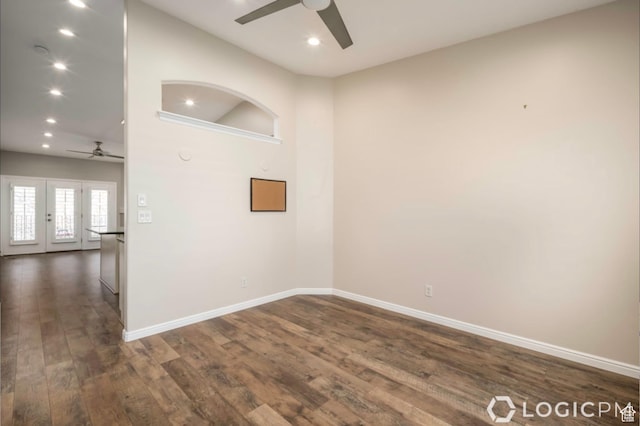 empty room featuring dark wood-style floors, baseboards, a ceiling fan, and french doors