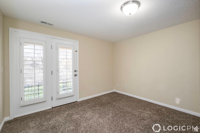 spare room with visible vents, baseboards, and carpet floors