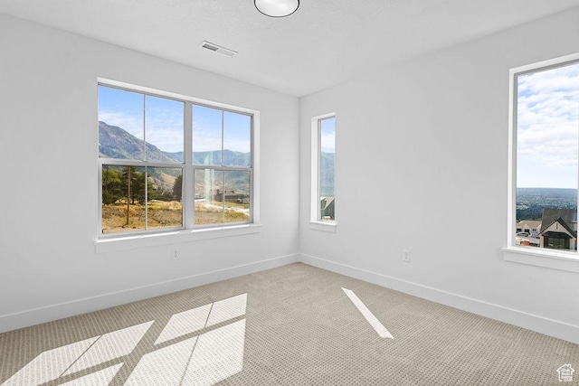 3666 W 2110 S Unit 103, Syracuse, UT 84075 - unfurnished room featuring baseboards, a mountain view, visible vents, and light colored carpet