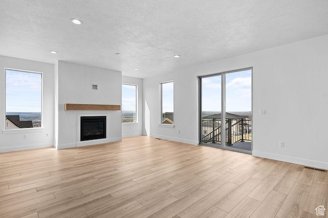 3666 W 2110 S Unit 103, Syracuse, UT 84075 - unfurnished living room with visible vents, light wood-style flooring, and plenty of natural light