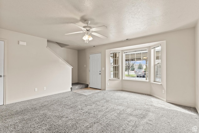 1762 N 460 W Unit 103-10, Logan, UT 84341 - unfurnished living room featuring baseboards, a ceiling fan, carpet, and stairs