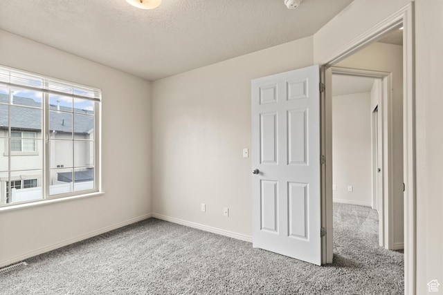 1762 N 460 W Unit 103-10, Logan, UT 84341 - spare room featuring carpet floors, baseboards, visible vents, and a textured ceiling