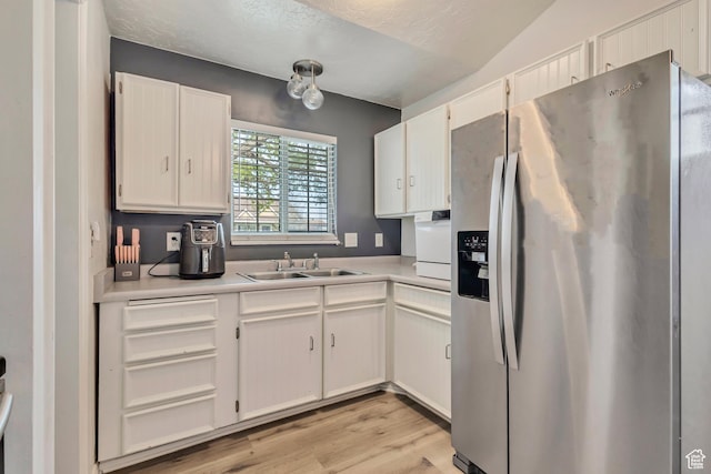 2683 S Melville Dr, Magna, UT 84044 - kitchen featuring a sink, stainless steel refrigerator with ice dispenser, light countertops, white cabinets, and light wood-style floors