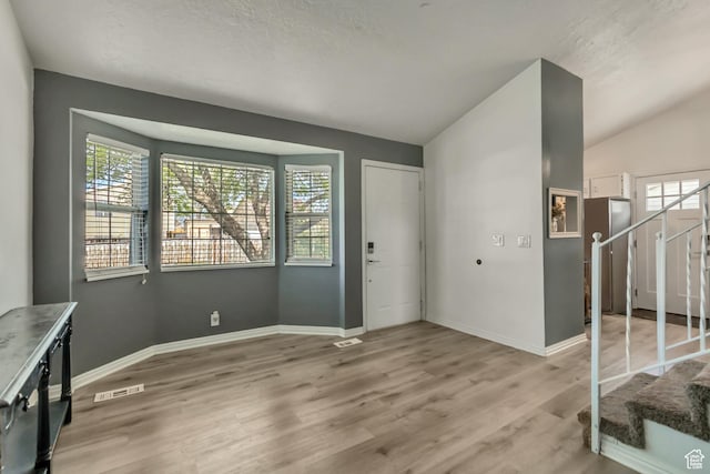2683 S Melville Dr, Magna, UT 84044 - entrance foyer with stairs, a wealth of natural light, light wood-style floors, and visible vents