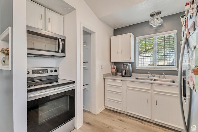 2683 S Melville Dr, Magna, UT 84044 - kitchen featuring a sink, stainless steel appliances, white cabinetry, light countertops, and light wood-style floors