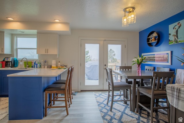 6100 W 3725 S, West Valley City, UT 84128 - dining space featuring a textured ceiling, light wood-style flooring, french doors, and recessed lighting