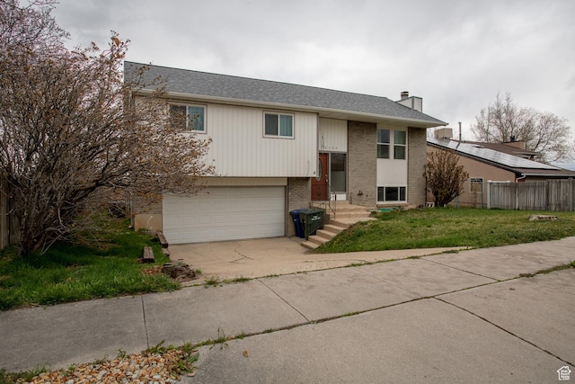 6100 W 3725 S, West Valley City, UT 84128 - raised ranch featuring fence, an attached garage, a chimney, a front yard, and brick siding