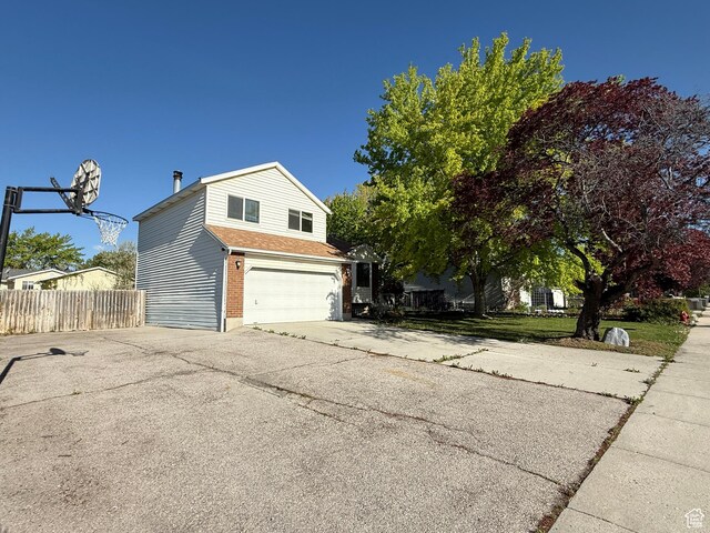 9294 S Vista W Dr W, West Jordan, UT 84088 - view of side of home with aphalt driveway, fence, and a garage