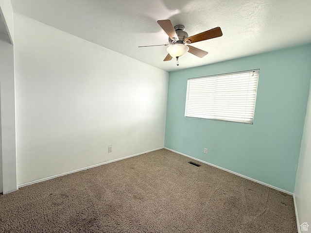 unfurnished room with carpet flooring, a ceiling fan, a textured ceiling, and visible vents