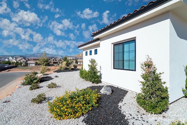 3169 S Pecos Dr, Washington, UT 84780 - view of property exterior featuring a residential view, a tile roof, stucco siding, and a mountain view