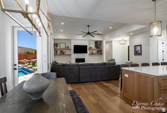 3169 S Pecos Dr, Washington, UT 84780 - living room with a brick fireplace, ceiling fan with notable chandelier, light wood finished floors, and recessed lighting