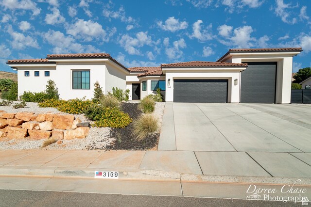3169 S Pecos Dr, Washington, UT 84780 - mediterranean / spanish home featuring a tiled roof, driveway, stucco siding, and an attached garage