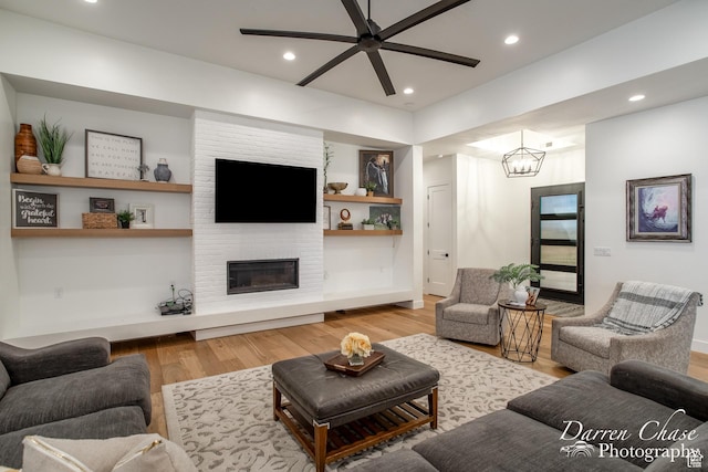 3169 S Pecos Dr, Washington, UT 84780 - living room featuring a fireplace, recessed lighting, light wood-style floors, and ceiling fan with notable chandelier