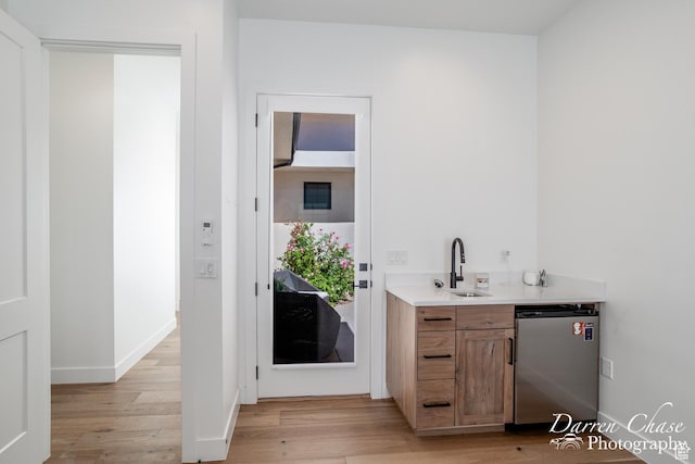 3169 S Pecos Dr, Washington, UT 84780 - bar with a sink, stainless steel dishwasher, light wood-type flooring, indoor wet bar, and baseboards