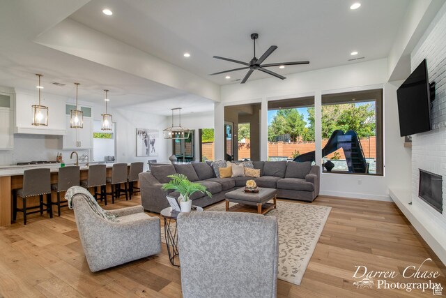 3169 S Pecos Dr, Washington, UT 84780 - living room with light wood-style flooring, baseboards, a fireplace, ceiling fan, and recessed lighting