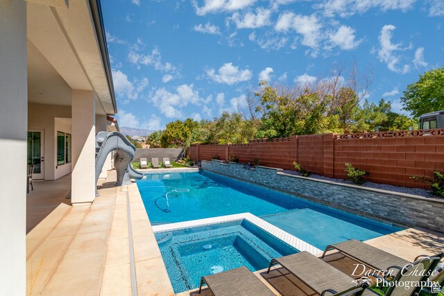 3169 S Pecos Dr, Washington, UT 84780 - view of pool featuring a water slide, a fenced in pool, a fenced backyard, an in ground hot tub, and a patio area