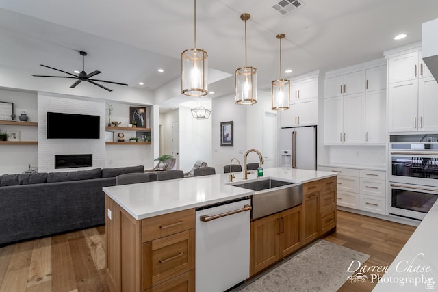 3169 S Pecos Dr, Washington, UT 84780 - kitchen featuring a sink, wood finished floors, open floor plan, white appliances, and visible vents
