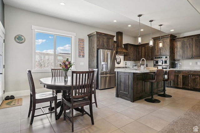 1713 E Viewside Cir, Hideout, UT 84036 - kitchen with a breakfast bar area, stainless steel appliances, wall chimney range hood, recessed lighting, and dark brown cabinets