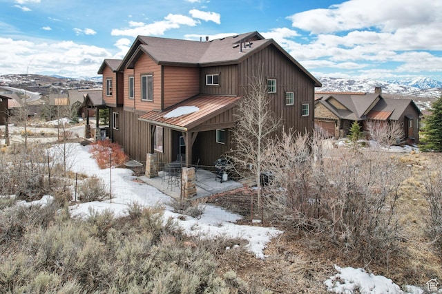 1713 E Viewside Cir, Hideout, UT 84036 - snow covered house with a mountain view, metal roof, a patio, and board and batten siding