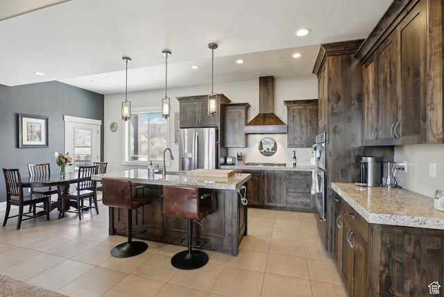 1713 E Viewside Cir, Hideout, UT 84036 - kitchen with a kitchen island with sink, appliances with stainless steel finishes, dark brown cabinetry, a sink, and custom range hood