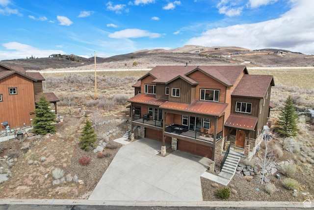 1713 E Viewside Cir, Hideout, UT 84036 - chalet / cabin featuring stone siding, metal roof, an attached garage, concrete driveway, and a mountain view