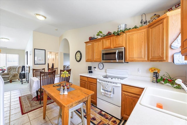 2050 W Canyon View Dr Unit 203, St George, UT 84770 - kitchen with white electric range oven, light countertops, stainless steel microwave, a sink, and vaulted ceiling