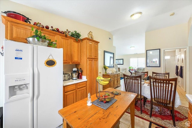 2050 W Canyon View Dr Unit 203, St George, UT 84770 - kitchen featuring light countertops, brown cabinets, lofted ceiling, white refrigerator with ice dispenser, and light tile patterned floors