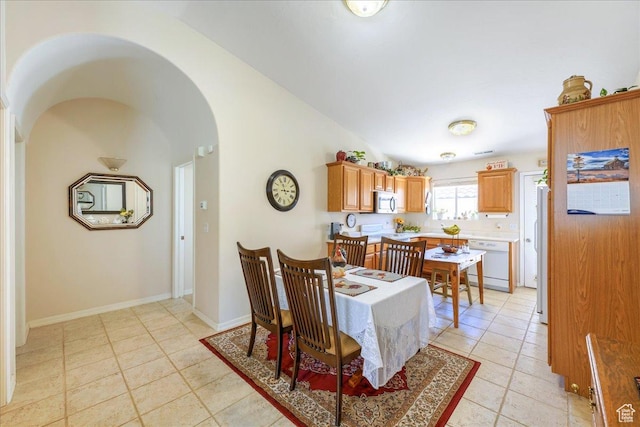 2050 W Canyon View Dr Unit 203, St George, UT 84770 - dining area featuring arched walkways, baseboards, vaulted ceiling, and light tile patterned floors