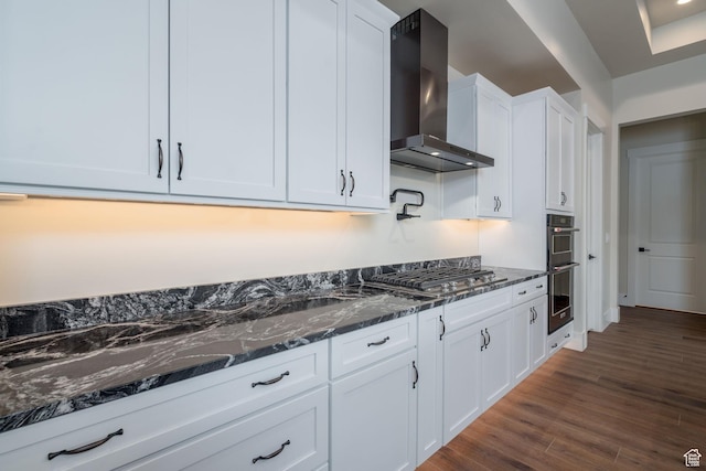 850 S Finley Cir Unit 239, North Salt Lake, UT 84054 - kitchen featuring wall chimney exhaust hood, stainless steel appliances, dark stone counters, white cabinetry, and dark wood-style floors