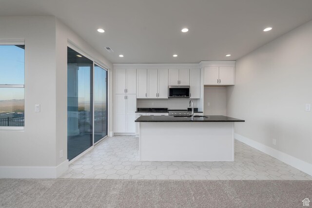850 S Finley Cir Unit 239, North Salt Lake, UT 84054 - kitchen with stainless steel microwave, a sink, white cabinetry, recessed lighting, and dark countertops