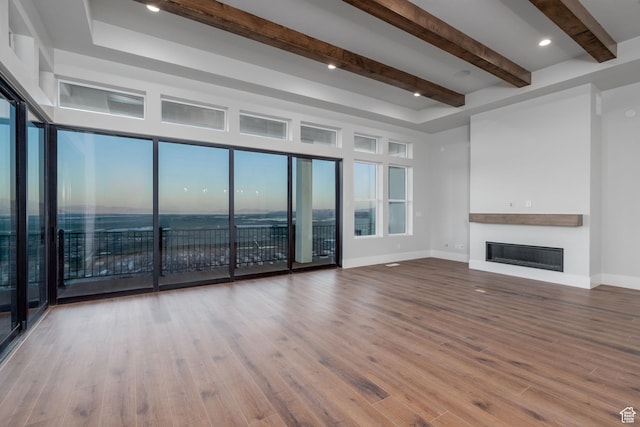 850 S Finley Cir Unit 239, North Salt Lake, UT 84054 - unfurnished living room featuring a glass covered fireplace, beamed ceiling, baseboards, and wood finished floors