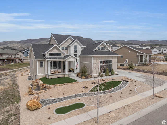 view of front of home with a residential view, driveway, a shingled roof, and a mountain view