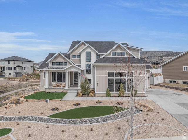 view of front of property with fence, an attached garage, board and batten siding, driveway, and covered porch
