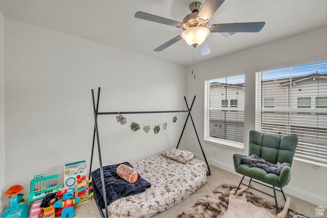 carpeted bedroom featuring baseboards and ceiling fan