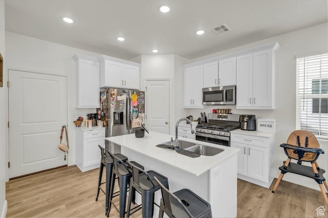 kitchen featuring white cabinets, light wood-style flooring, appliances with stainless steel finishes, and visible vents