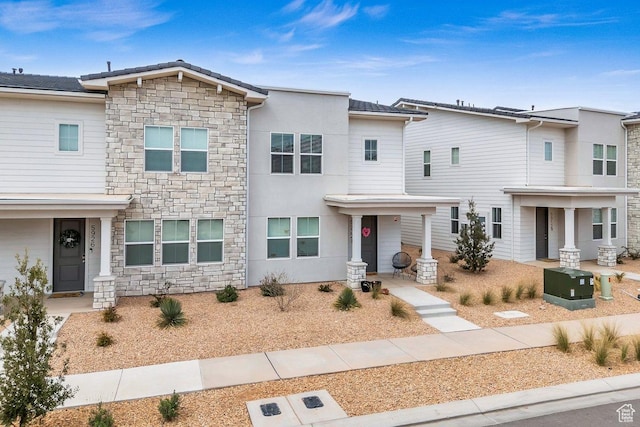 view of front of property featuring stone siding and stucco siding